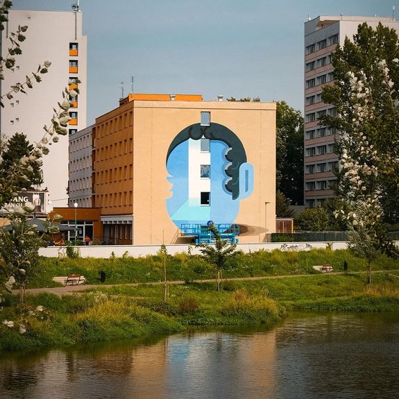 Co říkáte na nejnovější přírůstek do slušně se rozrůstající street artové 'galerie' na kolejích u Envelopy? 🎨 Na jižní stěně „Fischerek“ tento týden přibyl už osmý velkoplošný mural v univerzitním areálu – stylizovaný portrét Františka Palackého od renomovaného českého malíře Zbyňka Linharta.
.
Vytvořen byl při příležitosti oslav 450. výročí univerzity a připomínat má odkaz našeho novodobého dějinného patrona a „otce národa“. Otevřené dveře do neznáma, které jsou znázorněny v místě obličeje, jsou vzkazem v duchu hodnot, které Palacký vyznával – tedy že se nemáme bát nejisté budoucnosti a máme být stejně jako on otevření světu.
.
Děkujeme olomouckému Street Art Festivalu @safe_cz za další plodnou spolupráci!
.
.
.
#univerzitapalackeho #palackyuniversity #upol #olomouc #univerzitnimesto @linhart.zbynek